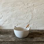 stoneware bowl and wooden whisk